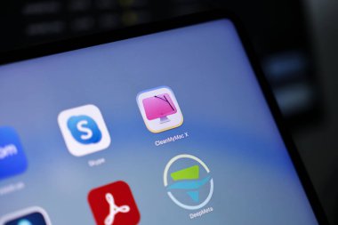 Poznan, Polonya - 15 Mayıs 2025: Şekillendirilmiş pembe monitör ve temizlik sileceği simgesini içeren temiz MyMac X logosu, dijital depolama ve Mac sistem performans geliştirme için kullanıldı