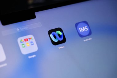 Poznan, Polonya - 15 Mayıs 2025: Ekran merkezindeki siyah zemin üzerinde sıvı gradyan döngü logosu içeren Webex uygulaması simgesi, çevrimiçi toplantılar, webinarlar ve sanal işbirliği oturumlarına ev sahipliği yapmak için kullanılır