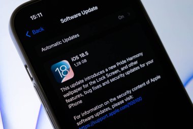 Poznan, Polonya - 15 Mayıs 2025: iPhone ekranında iOS 18.5 güncelleme bilgisi, yeni bir duvar kağıdı, önemli hata çözümleri ve aygıt için hayati güvenlik iyileştirmeleri yer alıyor