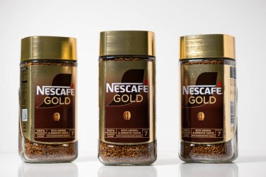 Poznan, Polonya - 2 Mayıs 2025: Benzer üç Nescafe altın hazır kahve kavanozu markanın zarif tasarımı ve kahve tanelerini vurgulayarak düz bir çizgide sergilenmektedir