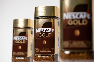 Poznan, Polonya - 2 Mayıs 2025: Üst üste üç Nescafe altın kahve kavanozu, marka ambalajı ve altın kavrulmuş Arabika kahvesi vurgulanıyor, editoryal gıda ve içecek için ideal