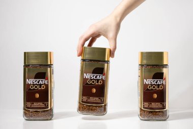 Poznan, Polonya - 2 Mayıs 2025: Nestle marka ve ürün deneyimini vurgulayan üç Nescafe altın hazır kahve kavanozu sergilenmektedir.