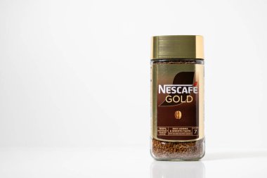 Poznan, Polonya - 2 Mayıs 2025: Bu stüdyo çekiminde Nestle marka ve zengin aromasını yumuşak bir tat için ön plana çıkaran Nescafe Gold 'un hazır kahvesinden oluşan cam bir kavanoz yer alıyor.