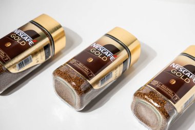 Poznan, Polonya - 2 Mayıs 2025: Bu yüksek açılı stüdyo çekiminde Nescafe Gold marka hazır kahve kavanozları, tanınan Nestle markasını ve altın kapaklarını vurguluyor.. 