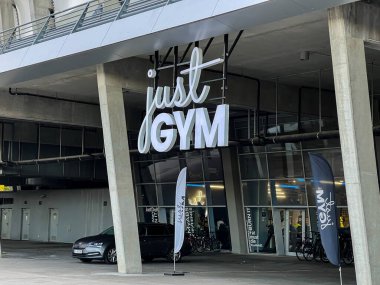 Poznan, Polonya - 22 Nisan 2025: Just GYM binasının dış görünüşü geniş stilize bir tabela sergiliyor, egzersiz ve eğitim için modern fitness merkezini tanımlıyor