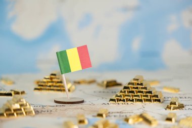 Mali 'yi temsil eden küçük bir bayrak, ulusal kaynak zenginliği, emtia değeri ve küresel ekonomik potansiyeli sembolize eden birçok küçük altın külçesiyle çevrili bir dünya haritasına yerleştirilmiştir.