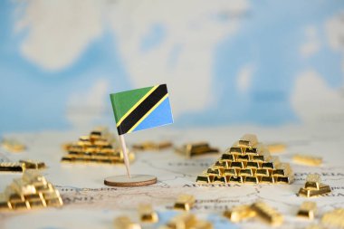 Dünya haritasındaki küçük bir Tanzanya bayrağı sayısız altın külçesiyle ülkenin zengin mineral zenginliğini ve uluslararası piyasalarda umut verici bir ekonomik geleceği simgeliyor.