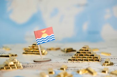 Bu yakın plan, ulusal refah, ekonomik büyüme ve yatırımı simgeleyen, küresel haritada bol miktarda parıldayan altın külçelerle çevrili minyatür bir Kiribati bayrağını tasvir ediyor.