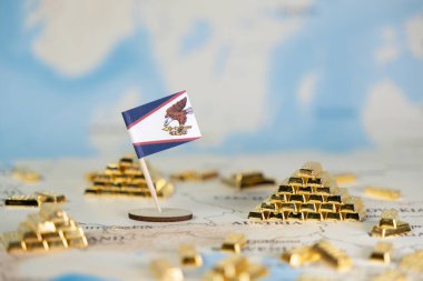 Amerikan Samoa bayrağı, uluslararası ticaret ve kaynak yönetimi vurgulanarak dünya haritasında sayısız pırıl pırıl altın külçesiyle belirgin bir şekilde sergilenmektedir.