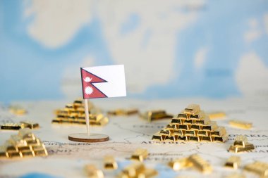Minyatür bir Nepal bayrağı, ulusal ekonomik istikrar ve küresel yatırımı sembolize eden, parlayan altın külçelerle çevrili ayrıntılı bir dünya haritasına yerleştirilmiştir.