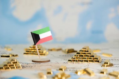 Minyatür Kuveyt bayrağı, ulusal refah, değerli kaynaklar ve ülkenin küresel ekonomik varlığını simgeleyen bir dünya haritasında altın barların yanında duruyor.