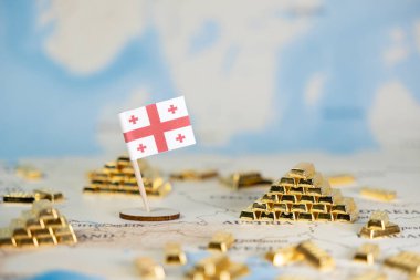 Dünya haritasında altın külçelerinin yanında duran minyatür Gürcistan bayrağı, ulusal ekonomik istikrar, kaynak potansiyeli ve küresel yatırım olanaklarını kopya alanı ile göstermektedir.