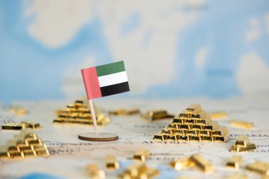Birleşik Arap Emirlikleri bayrağı, ulusal zenginlik, sağlam ekonomik strateji ve kopyalama alanı ile yatırım potansiyelini tasvir eden sayısız altın külçesiyle çevrili bir dünya haritasında yer alıyor.
