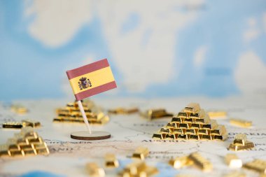 Dünya haritasındaki İspanyol bayrağı ve minyatür altın külçeleri ulusal ekonomik gücü, küresel finans ve yatırım potansiyelini sembolize ederek geniş bir kopya alanı sunmaktadır.