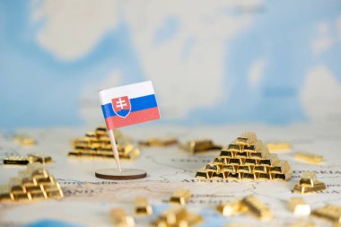 Ulusal ekonomik refahı, değerli rezervleri ve finansal geleceği temsil eden bulanık bir dünya haritasında küçük Slovakya bayrağı ve altın külçeleri