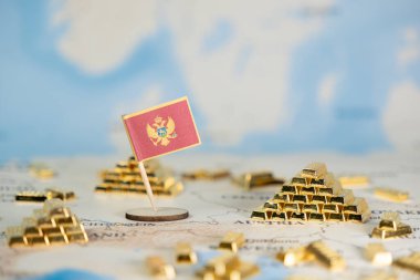 Ulusal ekonomik büyüme, yatırım ve küresel mali istikrarı gösteren, istiflenmiş ve dağınık altın külçelerle çevrili bir dünya haritasına yerleştirilmiş küçük bir Karadağ bayrağı