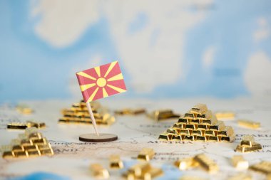 Ulusal ekonomik büyüme, yatırım ve stratejik mali fırsatları temsil eden altın çubuk piramitlerle çevrili küresel bir haritaya belirgin bir Kuzey Makedonya bayrağı yerleştirildi
