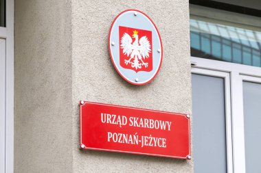 Poznan, Polonya - 30 Nisan 2025: Beton duvarda ulusal amblemi bulunan kırmızı bir Polonya Vergi Dairesi işareti (Urzad Skarbowy), devlet maliye hizmetlerini iletiyor