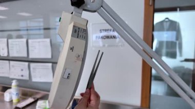 Bir profesyonelin eli dikkatle QC onaylı etiketli hassas bir büyüteç tutarak modern bir laboratuvar ortamında detaylı teftiş yaparak, doğru kalite kontrolü sağlar.