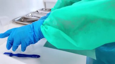 Koruyucu önlük giymiş eldivenli eller, kimyasal ve ilaç laboratuarlarında hassasiyeti gösteren plastik bir beher ile dikkatlice ölçülür.