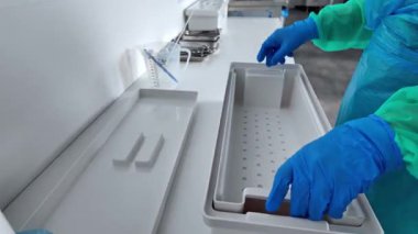 Cerrahi aletlerin temizlenmesi için titizlikle hazırlanmış beyaz sterilizasyon tepsileri, katı hijyen protokolleri ve steril prosedürleri vurgulanıyor.