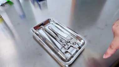 Poznan, Polonya - 1 Haziran 2025: Bir profesyonelin eli, cerrahi gereçlerle birlikte metal bir tepside sterilizasyon göstergesini ön plana çıkardı.