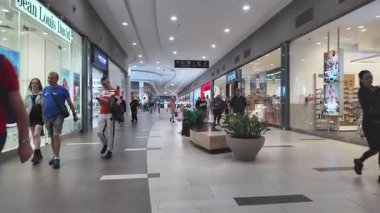 Poznan, Polonya - 2 Haziran 2025: Çağdaş perakende satış yapan Jean Louis David ve Empik 'in de aralarında bulunduğu seçkin mağazaların önünden geçen, modern bir alışveriş merkezini gezen çeşitli müşterilerin geniş bir görüntüsü