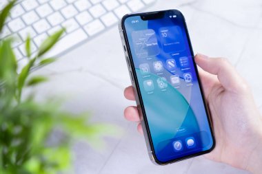Poznan, Polonya - 10 Haziran 2025: Yeni iOS 26 işletim sistemini yenilikçi Sıvı Cam ekran tasarımı ile gösteren modern bir akıllı telefon, geleceğin teknolojisini somutlaştırıyor