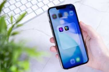Poznan, Polonya - 10 Haziran 2025: Yeni iOS 26 ve Sıvı Cam tasarımı kullanan ve güvenlik ve üretkenlik uygulamalarını içeren bir akıllı telefonun yakın çekimi