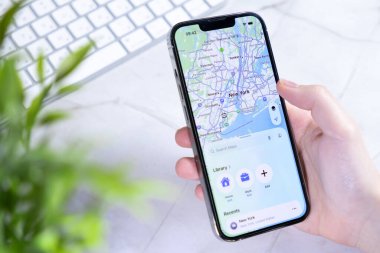 Poznan, Polonya - 10 Haziran 2025: Yeni iOS 26 Sıvı Cam Tasarımlı bu çağdaş akıllı telefon verimli şehir navigasyonuna yardımcı olan bir New York haritası sergiliyor