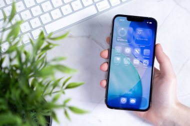 Poznan, Polonya - 10 Haziran 2025: Bir el yenilikçi Yeni iOS 26 işletim sistemini bir Sıvı Cam tasarımı ile modern dijital verimliliği artıran bir akıllı telefon ekranı sunar