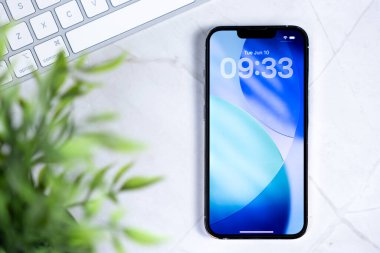 Poznan, Polonya - 10 Haziran 2025: Yeni IOS 26 ve Sıvı Cam tasarımı sergilenen akıllı telefon ekranının yakın çekimi, masaüstünde gelecekteki mobil arayüzü temsil ediyor