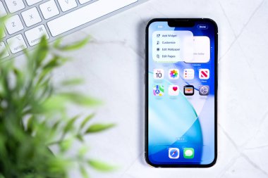 Poznan, Polonya - 10 Haziran 2025: Sıvı Cam tasarımı ile çığır açan yeni iOS 26 işletim sistemini gösteren modern bir Apple iPhone akıllı telefonu, arayüz özelleştirmesini vurguluyor