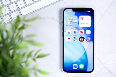 Poznan, Polonya - 10 Haziran 2025: Yeni iOS 26 işletim sistemi ve Sıvı Cam tasarımı sergilenen modern akıllı telefon, geleceğin teknolojisini ve dijital bağlantısını somutlaştırıyor
