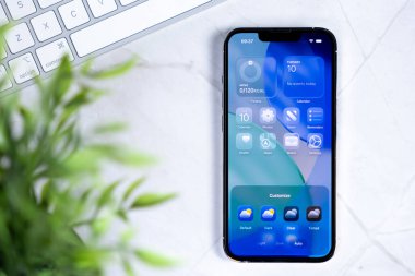 Poznan, Polonya - 10 Haziran 2025: Yeni iOS 26 ve Sıvı Cam telefon arayüzü sağlık, harita, cüzdan, haber, takvim gereçleri, gelecekteki dijital teknolojiyi gösteriyor