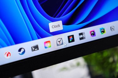 Poznan, Polonya - 6 Haziran 2025: Görev çubuğunu saat uygulamasını etkinleştiren bir fare imleci ile gösteren bir bilgisayar ekranının kapatılması, modern yazılım arayüzlerinin ve zaman tutumunun vurgulanması