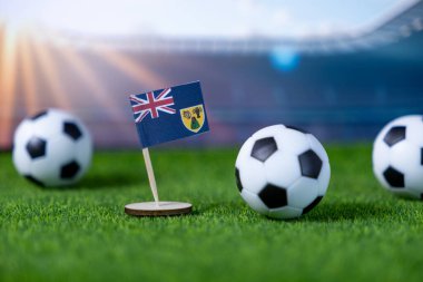 Miniature Turks and Caicos Islands flag surrounded by soccer balls on artificial turf, against a vibrant stadium, representing football fandom and national team spirit in championship