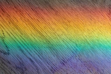 Soyut ışık spektrumu canlı gökkuşağı renklerini desenli ahşap bir yüzeye yansıtıyor. Fizik kavramları, sanat veya çeşitli arka planlar için mükemmel.