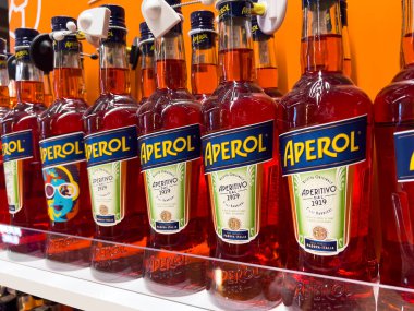 Poznan, Polonya - 7 Haziran 2025: Aydınlık bir mağaza rafında düzgünce dizilmiş birden fazla Aperol şişesinin yakın görüntüsü, ikonik turuncu içeceği ve mevcut perakendeciliğini vurguluyor