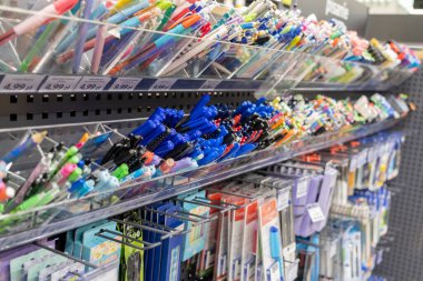 Renkli kalemler, kalemler ve çeşitli kırtasiye malzemelerinin çoklu perakende raflarına yakın plan çekimleri, Polonya metni Pisanie (yazılar) eğitim amaçlı alışveriş için görünür