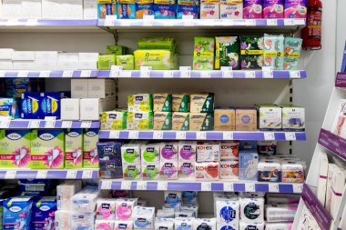 Poznan, Polonya - 30 Haziran 2025: Parlak bir perakende mağazasında düzenli olarak depolanan hijyenik ped ve tamponlar günlük kadın sağlığı ve refahı için çeşitli seçenekler sunuyor