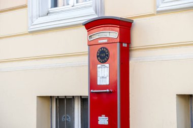 Poznan, Polonya - 18 Haziran 2025: SPRAWDZ ILE WAZYSZ metnini gösteren bir bina duvarına monte edilmiş kırmızı bir kamusal tartı, vintage tasarımı