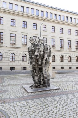 Poznan, Polonya - 18 Haziran 2025: Golema David Cerny 'nin katmanlı insan figürleri sergilenen soyut metal heykeli, tarihi bir kaldırım taşı plazasında, modern sanat ifadesini somutlaştırıyor.