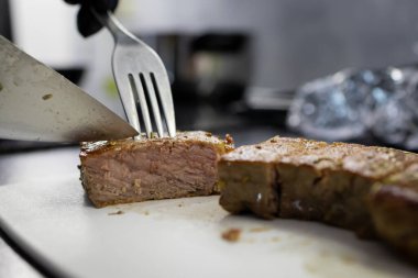 Mükemmel pişirilmiş, sulu, dilimlenmiş, hassas dokuyu ortaya çıkaran, yüksek kaliteli yemek hazırlamak için profesyonel mutfak ortamının yakın çekimi.