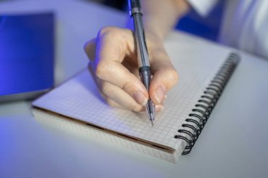 Akademik veya ticari başarı için özenli not alma, çalışma ve yaratıcı planlamayı temsil eden açık bir kılavuz defterin üzerinde odaklanmış bir bireyin eliyle yakın plan çekimi