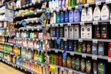 Poznan, Polonya - 26 Haziran 2025: Renkli kişisel bakım ürünleri şişeleriyle dolu iyi stoklanmış süpermarket raflarının yakın görüntüsü, tüketicilere çeşitli seçenekler sunuyor