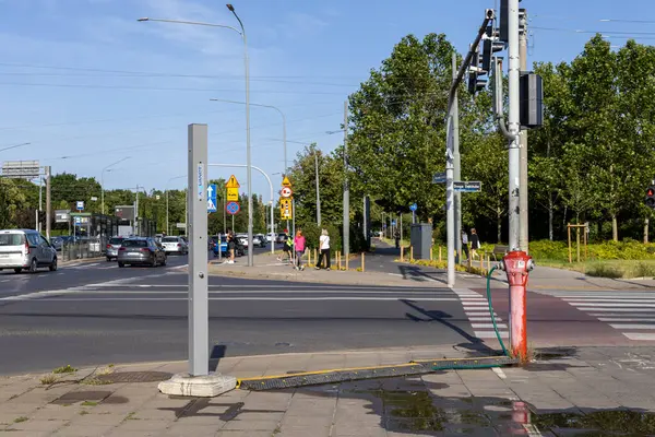 Poznan, Polonya - 26 Haziran 2025: AQUANET elektrik direği ve Droga Debinska 'da su sızdıran kırmızı bir yangın musluğu,
