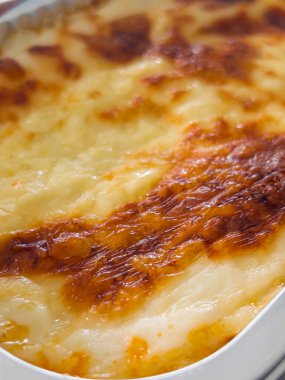 Yukardan aşağıya, köpüklü erimiş peynirli kahverengi lazanya, aile yemeği için ev yapımı geleneksel konforlu yemekleri sembolize ediyor.