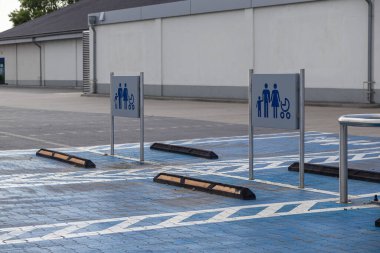 Aileler ve bebek arabaları için mavi işaretli özel koyları olan boş bir açık hava parkı, büyük bir perakende mağazasının yakınındaki uygun öncelikli erişimi sağlıyor.