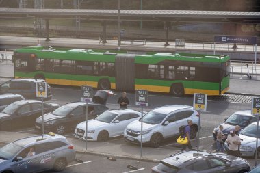 Poznan, Polonya - 13 Temmuz 2025: Poznan Glowny 'de modern eklemli bir otobüs ve yolcu bekleyen SUPER taksici araçları ile yoğun bir şehir ulaşım merkezi
